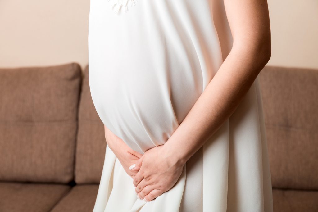 New mother holding baby, representing postpartum hemorrhoid recovery and treatment options CATEGORY: Hemorrhoid Treatment